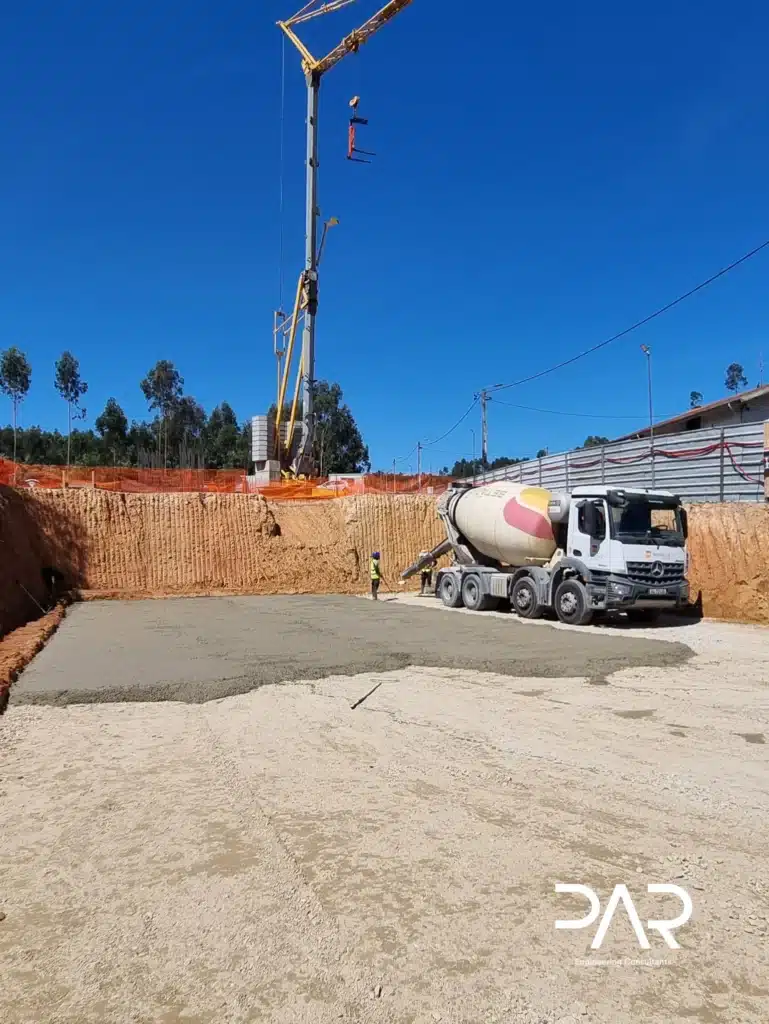 Betonagem da camada de limpeza com apoio de grua e autobetoneira.